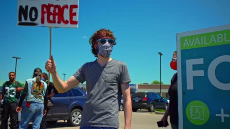 Janesville-Wisconsin-Usa-Cámara-Lenta-De-Un-Manifestante-Caucásico-Sosteniendo-Un-Cartel-Sin-Justicia-No-Hay-Paz-Vidas-Negras-Importan-Protestas-En-América-Gente-Blanca-Mostrando-Solidaridad