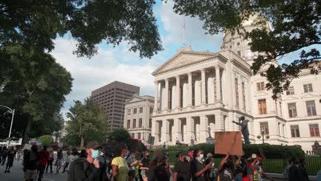 A-diverse-crowd-of-young-millennials-march-in-the-street-holding-signs-while-protesting-for-Black-Lives-Matter-and-social-justice-outside-of-the-Georgia-state-capitol-in-Atlanta