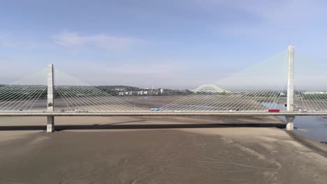 Landmark-Mersey-Gateway-bridge-traffic-crossing-river-Mersey-aerial-view-skyline-slow-push-in