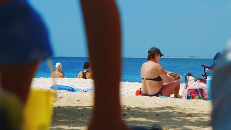 Turistas-Disfrutando-Del-Sol-En-La-Playa-De-Te-Amo,-Bonaire