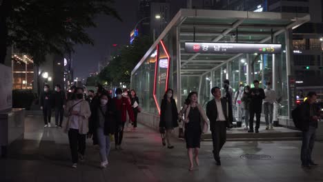 Korean-people-commuting-in-downtown-Gangnam-station-wearing-face-masks-at-night,-covid-19-pandemic,-static,-Seoul,-South-Korea