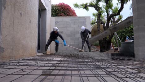 Trabajadores-De-La-Construcción-Usando-Paletas-Para-Llevar-El-Cemento-A-Todas-Partes