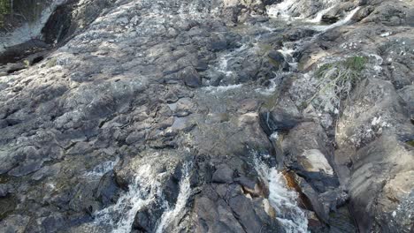 Minyon-Falls---Stream-Flowing-On-Rocks-Towards-Steep-Cliff-In-The-Northern-Rivers-Region,-Australia
