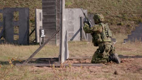Soldier-firing-rifle-during-military-exercise-in-shooting-range,-handheld,-midshot