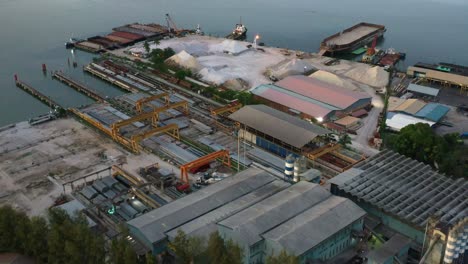 Aerial-flyover-Lee-Trading-Company-shipyard-at-lumut-port-industrial-park-with-sand-and-gravel-piles-at-the-site,-Kampung-Acheh,-Perak,-Malaysia
