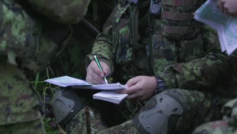 Soldiers-planning-strategy-in-the-forest,-mid-shot,-handheld,-slow-motion