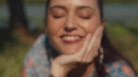 A-close-up-shot-of-the-face-of-an-attractive-Caucasian-female,-her-eyes-closed-resting-her-chin-on-the-palm-of-her-hand-dollying-out