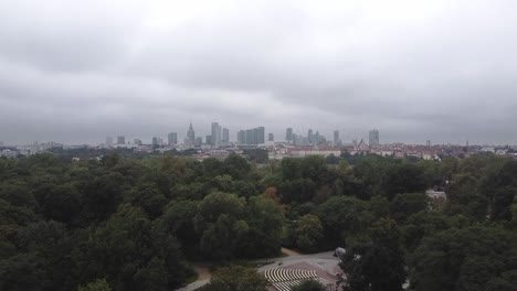Slow-drone-pan-footage-of-warsaw-city-skyline-in-front-of-a-forest