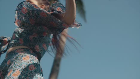 A-low-angle-shot-of-a-carefree-Caucasian-female-twirling-around-dancing-in-her-pretty-floral-dress-feeling-free-on-a-beautiful-summer’s-day-outdoors