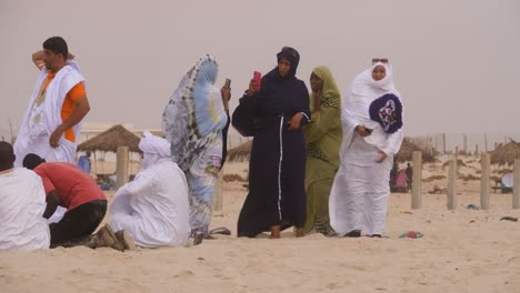 Algunos-Hombres-Y-Mujeres-Disfrutan-De-La-Playa-En-Un-Día-Ventoso