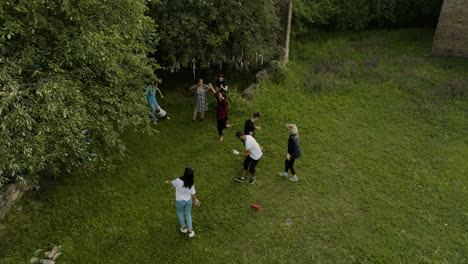 Family-celebrating-and-dancing-traditional-dances-under-trees,-Georgia