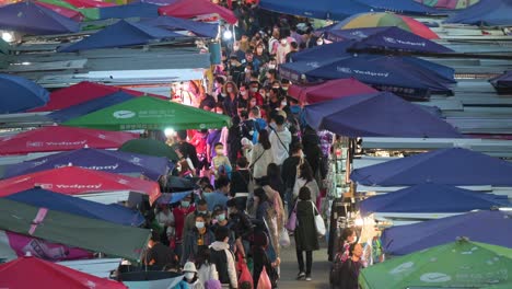 Overhead-shot-view-of-a-crowded-Fa-Yuen-street-stall-market-during-nighttime-as-people-look-for-bargain-priced-vegetables,-fruits,-gifts,-and-fashion-goods-in-Hong-Kong