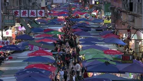 Vista-De-Pájaro-De-Un-Mercado-Abarrotado-De-Puestos-De-La-Calle-Fa-Yuen-Durante-La-Noche-Mientras-La-Gente-Busca-Verduras,-Frutas,-Regalos-Y-Artículos-De-Moda-A-Precio-De-Ganga-En-Hong-Kong