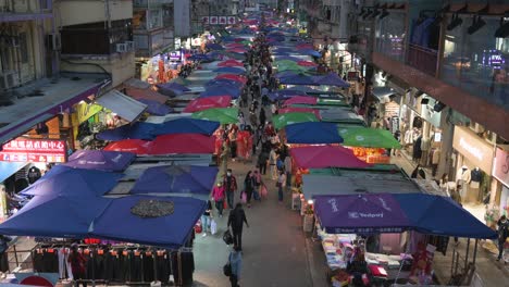 Bird's-eye-view-of-an-overcrowded-Fa-Yuen-street-stall-market-during-nighttime-as-people-look-for-bargain-priced-vegetables,-fruits,-gifts,-and-fashion-goods-in-Hong-Kong