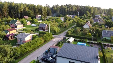 Couple-walk-on-street-in-small-calm-village-area,-aerial-view