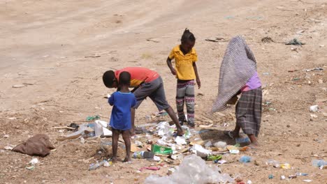 Four-brothers,-two-boys-and-two-girls,-looking-for-something-useful-in-the-garbage