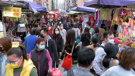 La-Gente-Camina-A-Través-De-Un-Concurrido-Mercado-De-Puestos-Callejeros-Al-Aire-Libre-Mientras-Buscan-Verduras,-Frutas,-Regalos-Y-Artículos-De-Moda-A-Precio-De-Ganga-En-Hong-Kong