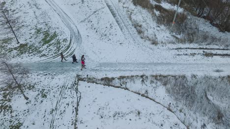 Aerial-shot-of-people-walking-in-the-snow-caped-road