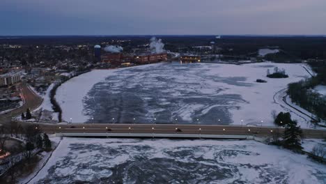 Aerial,-Stevens-Point-during-winter,-frozen-Wisconsin-River-in-the-evening