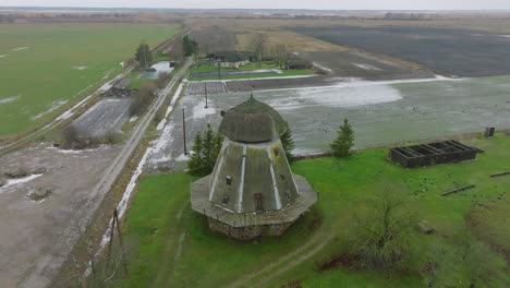 Beautiful-aerial-establishing-view-of-old-wooden-windmill-in-the-middle-of-the-field,-Prenclavu-windmill-,-overcast-winter-day,-wide-point-of-interest-drone-shot