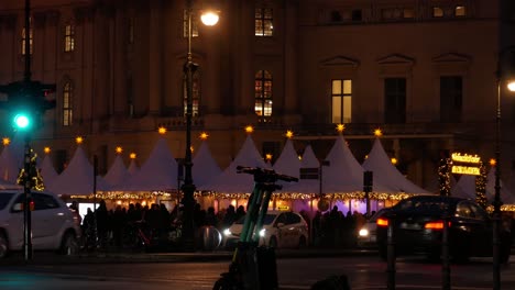 Berlin-city-street-and-glowing-Christmas-market-tents,-static-view