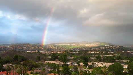 Aerial-View-of-Rainbow-Above-Valley-and-Hills,-Santa-Clarita,-Los-Angeles-CA-USA,-Pedestal-Drone-Shot