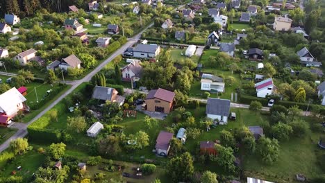 Small-summer-homes-on-warm-evening,-aerial-drone-view