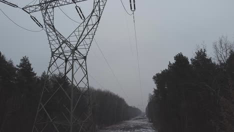Revealing-shot-of-power-lines-and-snowy-forest-on-a-snowy-winter-day-in-warsaw-poland