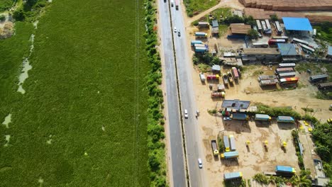 Los-Vehículos-Se-Mueven-Desde-Una-Hermosa-Carretera-En-La-Ciudad-De-Dhaka-Cerca-De-Un-Lago