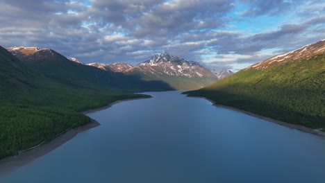 Eklutna-Lake-With-Snowcapped-Mountains-And-Cloudy-Sky-In-Anchorage,-Alaska---aerial-drone-shot