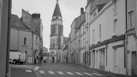 Gente-En-La-Calle-Con-La-Iglesia-De-Saint-jacques-En-El-Casco-Antiguo-De-La-Doutre-En-Ira,-Francia