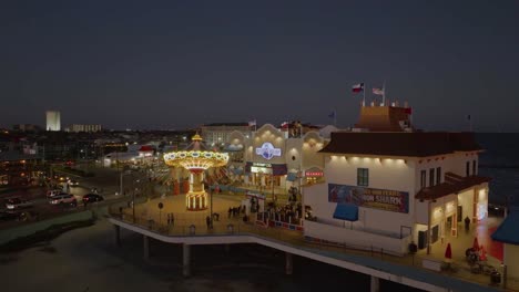 Aerial-view-in-front-of-the-Gulf-Glider-at-Galveston-Island-Pier,-dusk-in-Texas,-USA