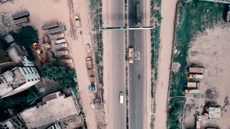 Aerial-shot-of-a-busy-road-where-vehicles-are-passing-in-Dhaka,-Bangladesh
