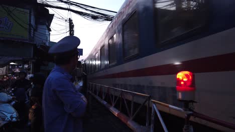 Low-angle-of-Saigon-to-Hanoi-train-traveling-through-a-busy-Saigon-street-in-early-morning