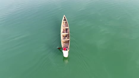 Aerial---Overhead-shot-of-a-man-rowing-his-canoe-in-a-lake