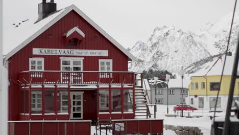 Eislandschaft-Des-Dorfes-Kabelvåg,-Norwegen-Mit-Einem-Roten-Haus-Im-Vordergrund-Und-Schneebedeckten-Bergen-Im-Hintergrund