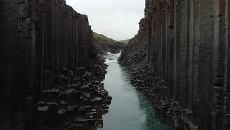 Basalt-rock-columns-on-banks-of-A-Bru-river,-Studlagil-Canyon,-Iceland