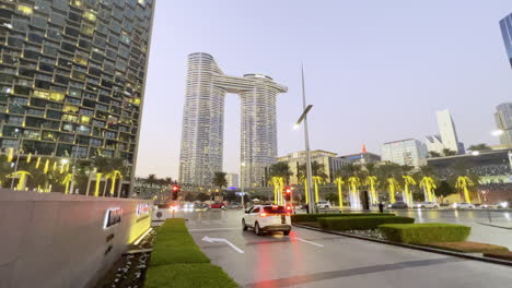 Centro-De-Negocios-Con-Una-Arquitectura-En-Forma-De-Barco-Visto-Al-Atardecer-Desde-Una-Intersección-De-La-Ciudad-En-Dubai