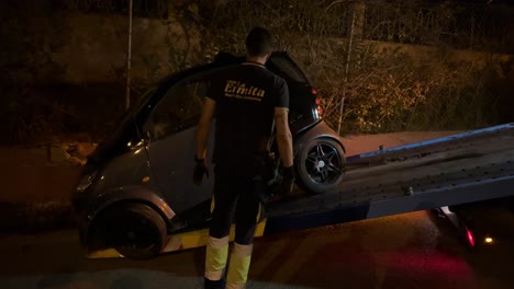 Un-Camión-De-Remolque-Cargando-Y-Tirando-De-Un-Auto-Inteligente-Por-La-Noche-Después-De-Un-Gran-Accidente-De-Tráfico,-Auto-Completamente-Roto,-Seguro-De-Auto,-Seguro-De-Salud,-Toma-De-4k