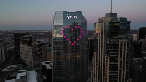 Aerial-descending-shot-at-sunset-showing-Optiv-building,-Four-Seasons-Hotel,-and-skyline-of-Denver,-Colorado