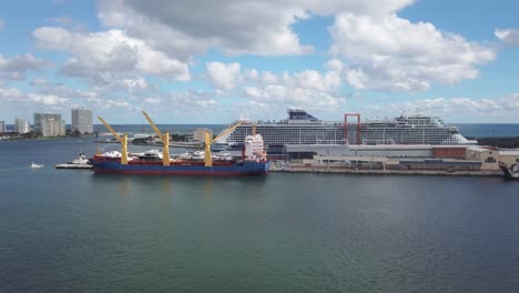 Frachtschiff-Beladen-Mit-Yachten-Und-Massiven-Kreuzfahrtschiffen,-Die-Passagiere-Im-Seehafen-Von-Florida-Laden