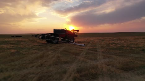 Filmische-Sonnenuntergangsantenne-In-Richtung-Horsch-Autonomer-Sprühtraktor-Auf-Ackerland