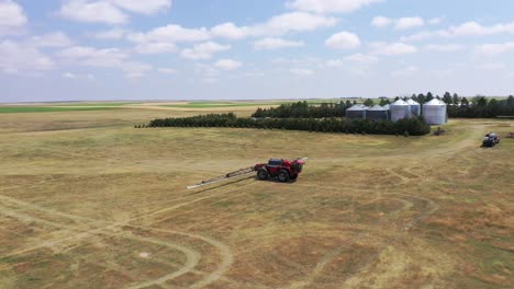 Toma-Aérea-De-Un-Gran-Tractor-Rociador-Horsch-Rojo-En-Una-Vasta-Tierra-Agrícola