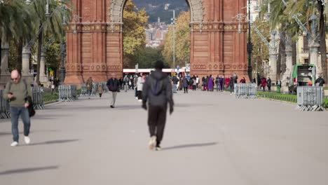 Poderoso-Hombre-Borroso-Camina-Hacia-Arc-De-Triomf-En-Barcelona,-Vista-Trasera-En-Cámara-Lenta