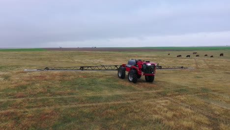 HORSCH-sprayer-tractor-driving-over-farm-land---descending-drone-shot