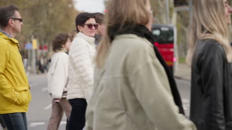 Group-of-pedestrians-walk-over-crosswalk-in-Barcelona,-slow-motion-view