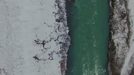 Iceland-in-winter-snowy-river-overhead-scroll-to-the-right-overhead-Drone-4K