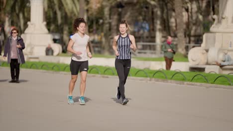 Weibliche-Freunde-Joggen-In-Barcelona-Stadt-An-Einem-Sonnigen-Warmen-Tag,-Zeitlupe