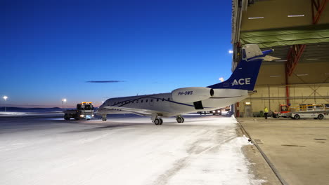 Twin-engine-Jet-Ace-E135-Being-Towed-From-The-Hangar-Of-Arvidsjaur-Airport-In-Sweden-At-Twilight