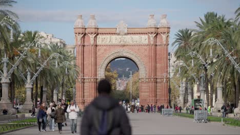 Iconic-Arc-de-Triomf-in-Barcelona-and-crowd-of-people-walk,-slow-motion-view